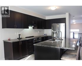 A kitchen with black cabinets and a granite countertop.