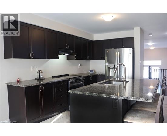 A kitchen with black cabinets and a granite countertop.