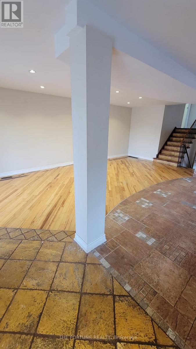 A room with a wooden floor and a white pillar.