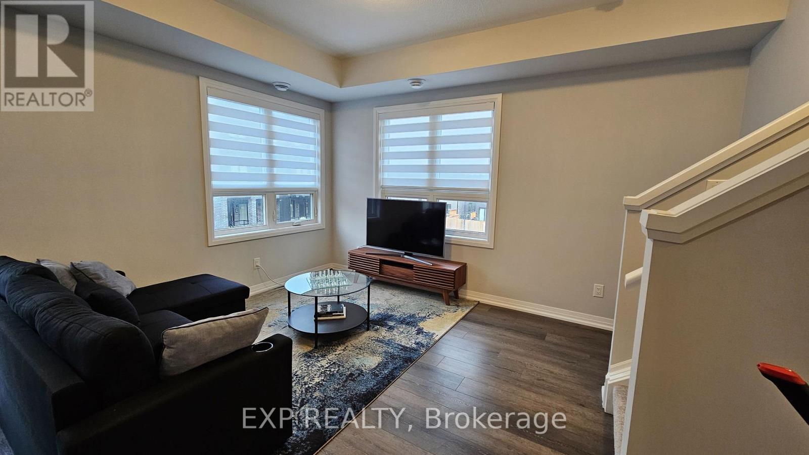 A living room with a black couch and a wooden coffee table.