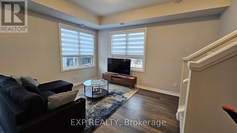A living room with a black couch and a wooden coffee table.