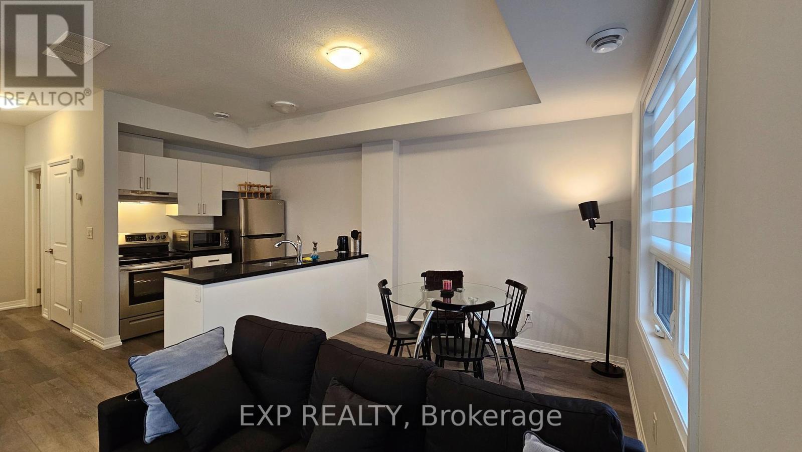 A modern kitchen with a dining table set for two.