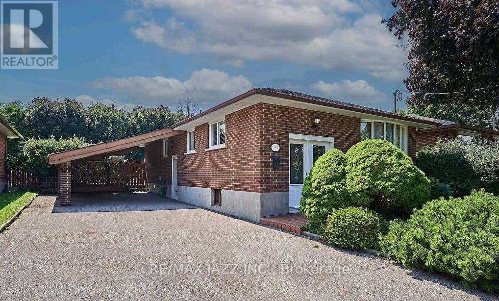 A house with a red brick exterior and a white door is for sale.