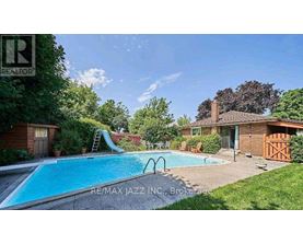 A swimming pool in a backyard with a slide and a house in the background.