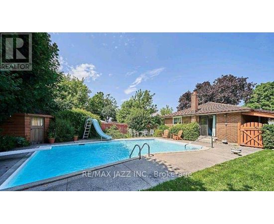 A swimming pool in a backyard with a slide and a house in the background.