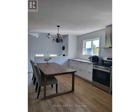 A dining room with a wooden table and chairs.