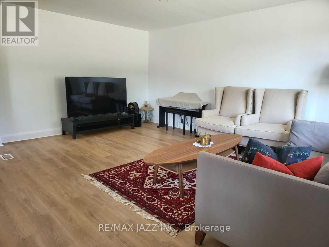 A living room with a couch, chair, and television.