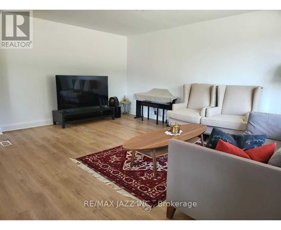 A living room with a couch, chair, and television.
