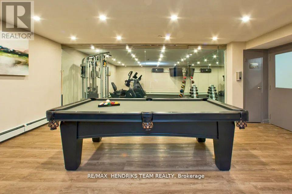 A pool table in a room with a brokerage sign.