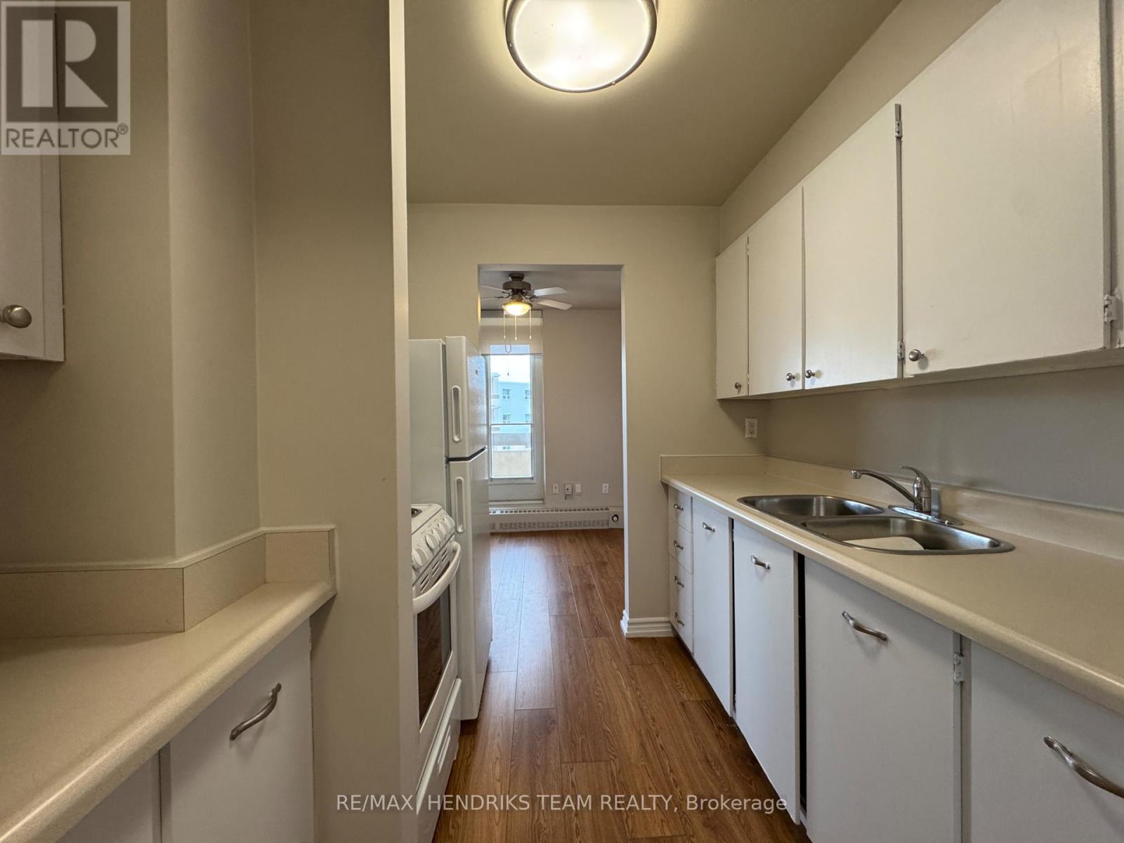 A kitchen with white cabinets and a sink.