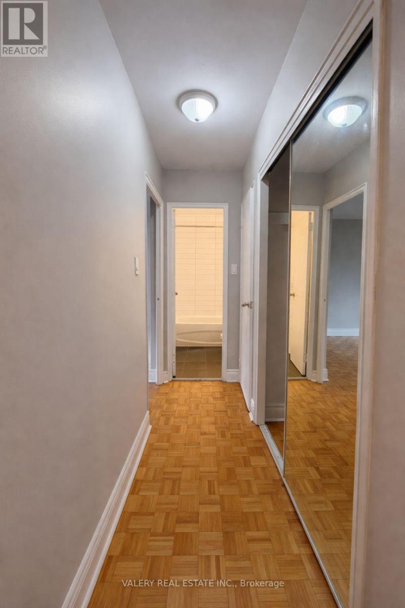 A hallway with wooden floors and white walls.