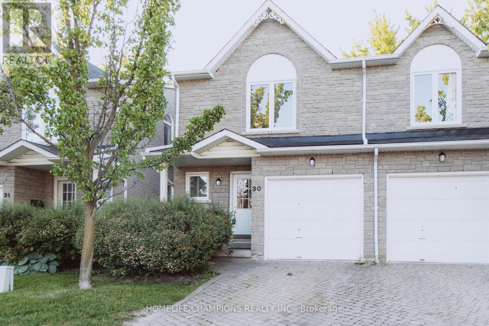 A two-story house with a garage and a driveway.