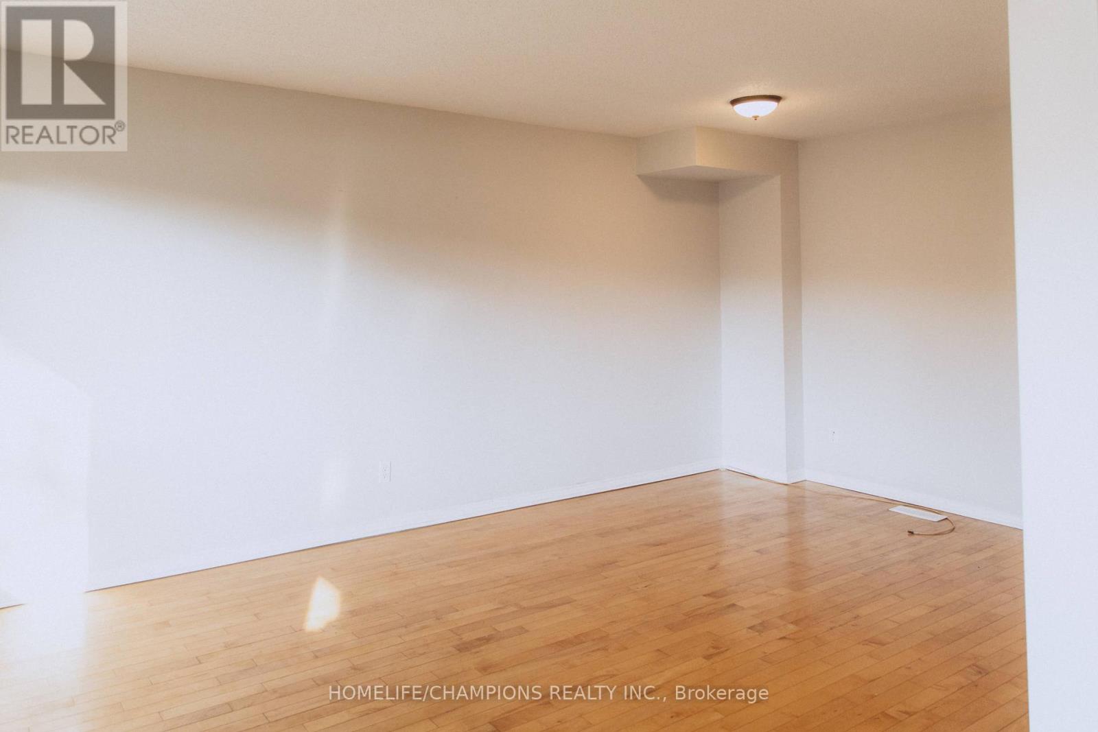 A room with wooden flooring and white walls.
