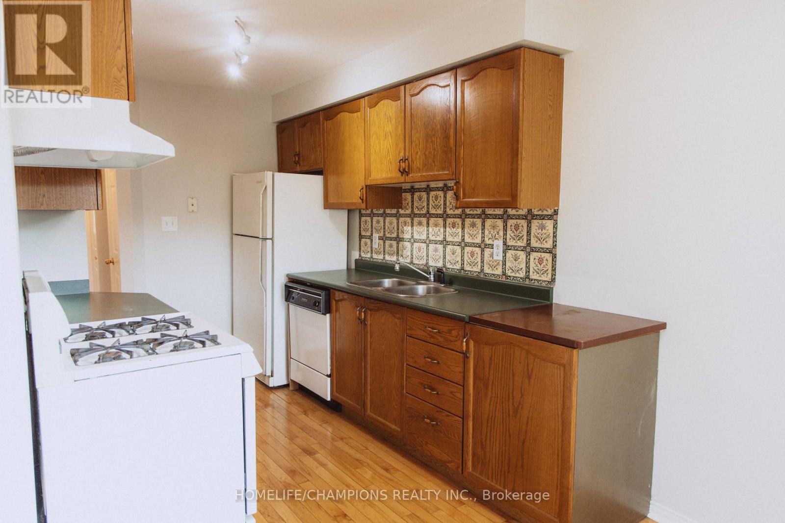 A kitchen with wooden cabinets and a white refrigerator.