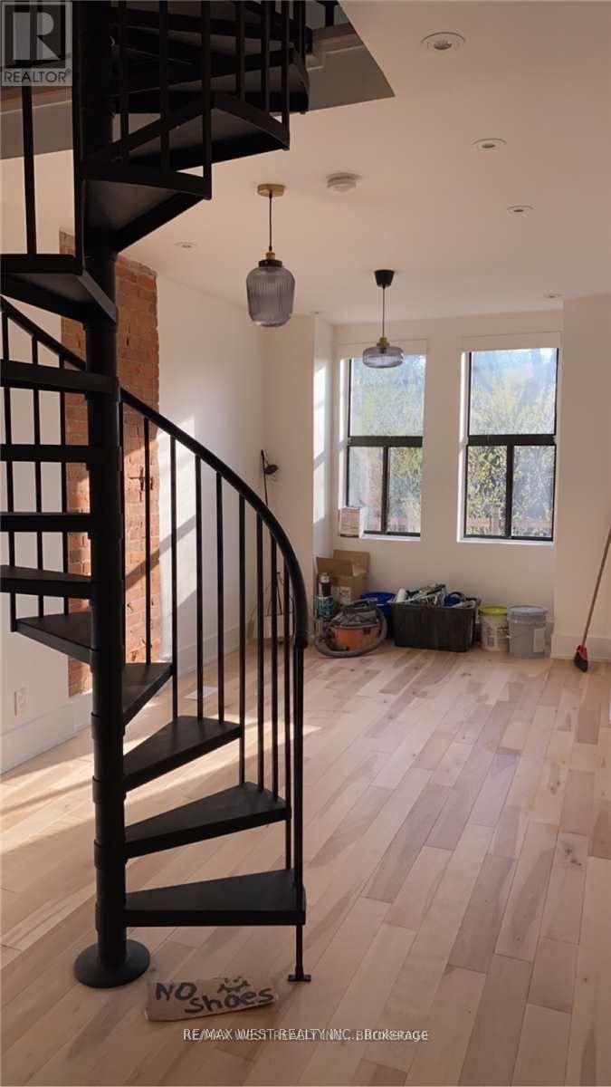 A room with a spiral staircase and a sign that says "NO SMOKING REAL ESTATE".