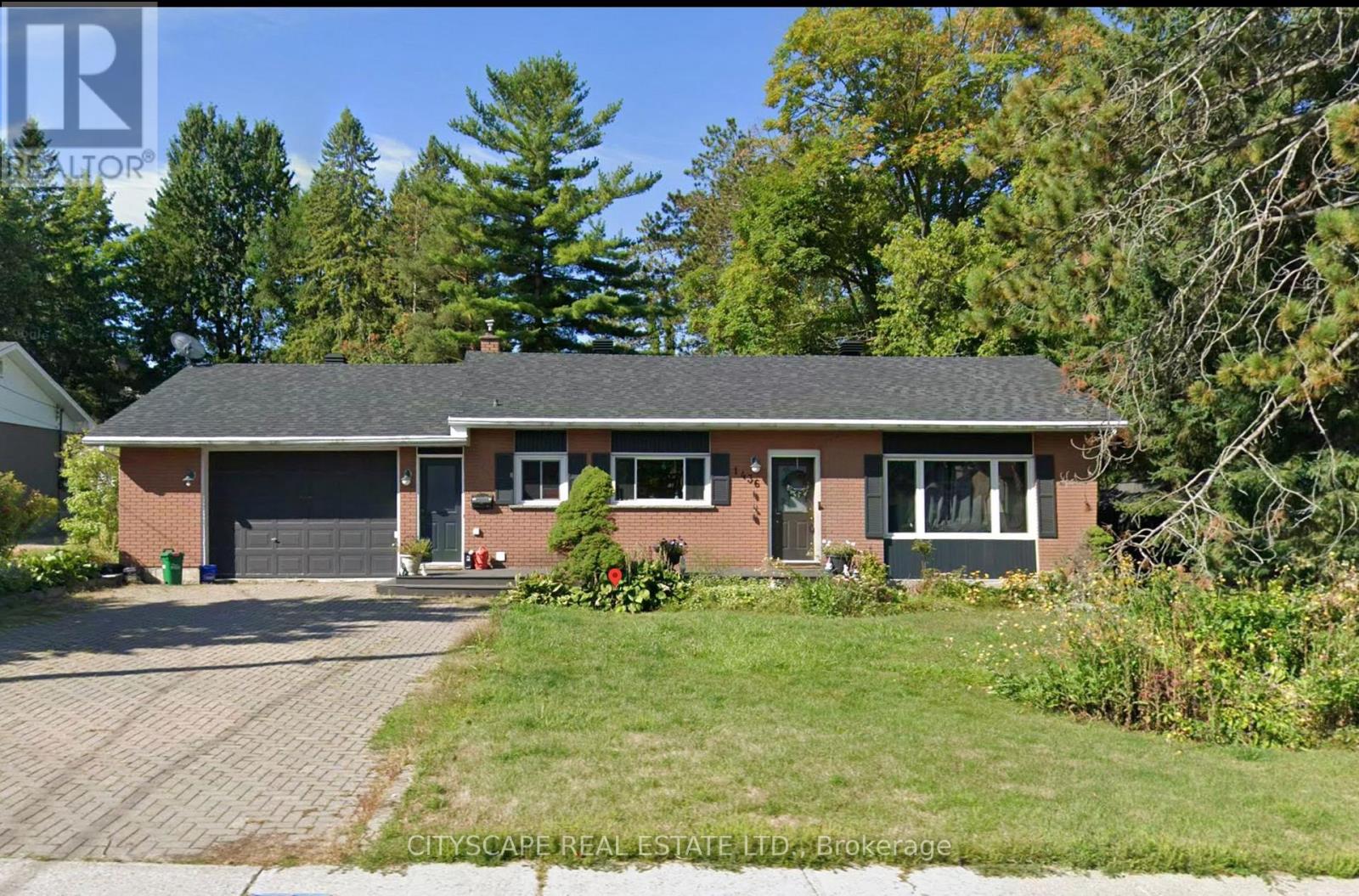 A house with a garage and a driveway in front of it.