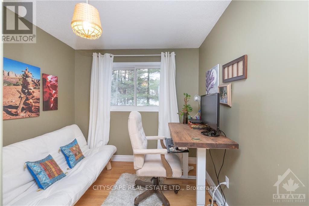 A living room with a white couch, a wooden table, and a painting on the wall.