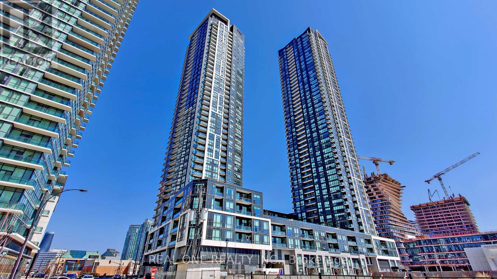 Two tall buildings with blue glass windows stand in front of a construction site.