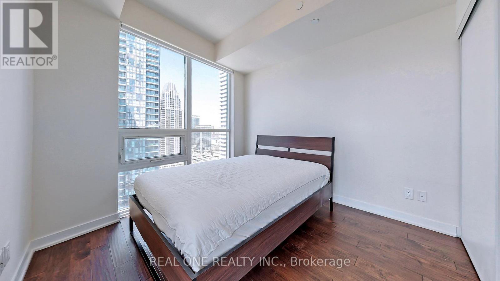 A bedroom with a large bed and a view of the city.