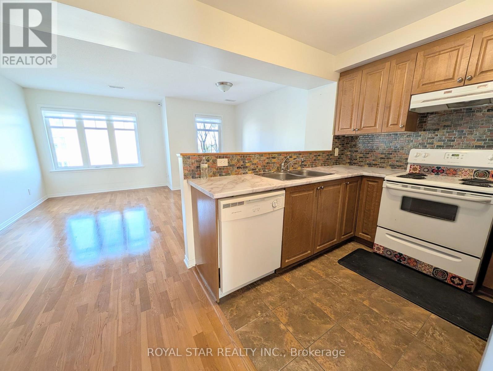 A kitchen with wooden cabinets and a tiled backsplash.