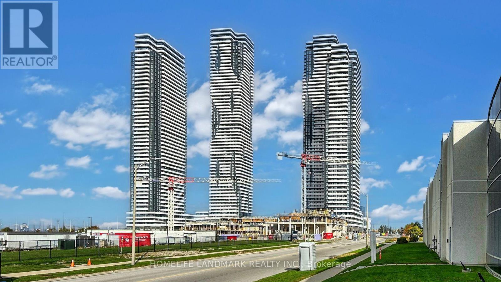 Three tall buildings under construction with a blue sky in the background.