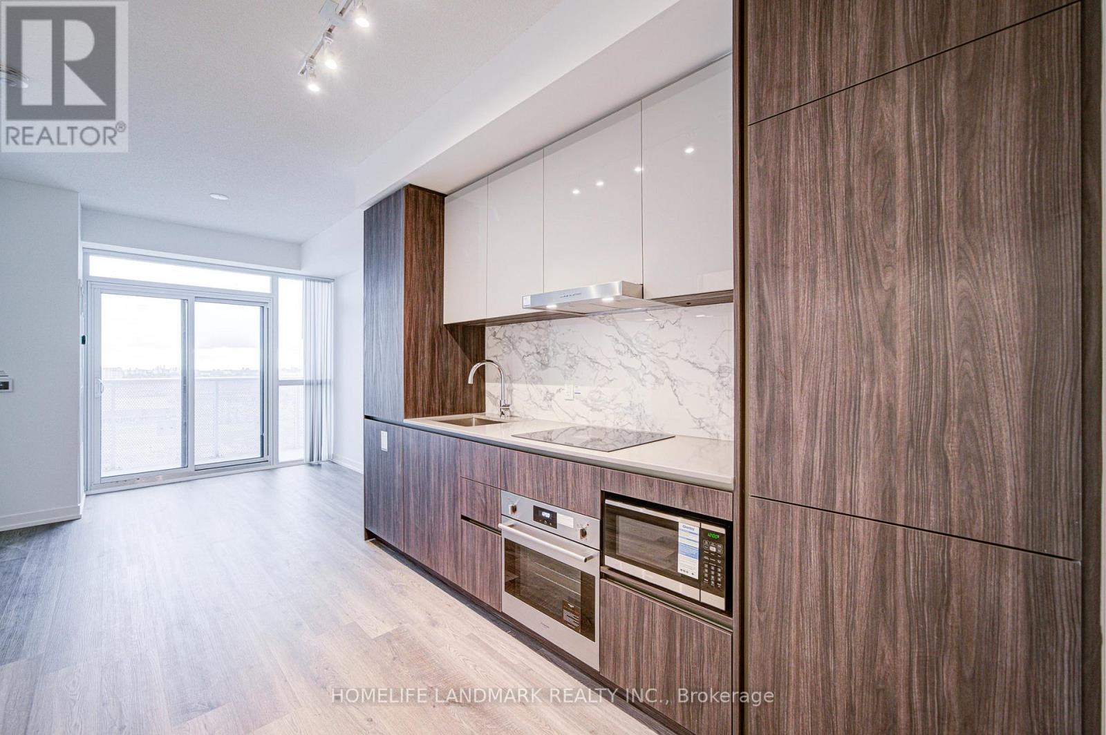 A modern kitchen with wooden cabinets and a marble countertop.