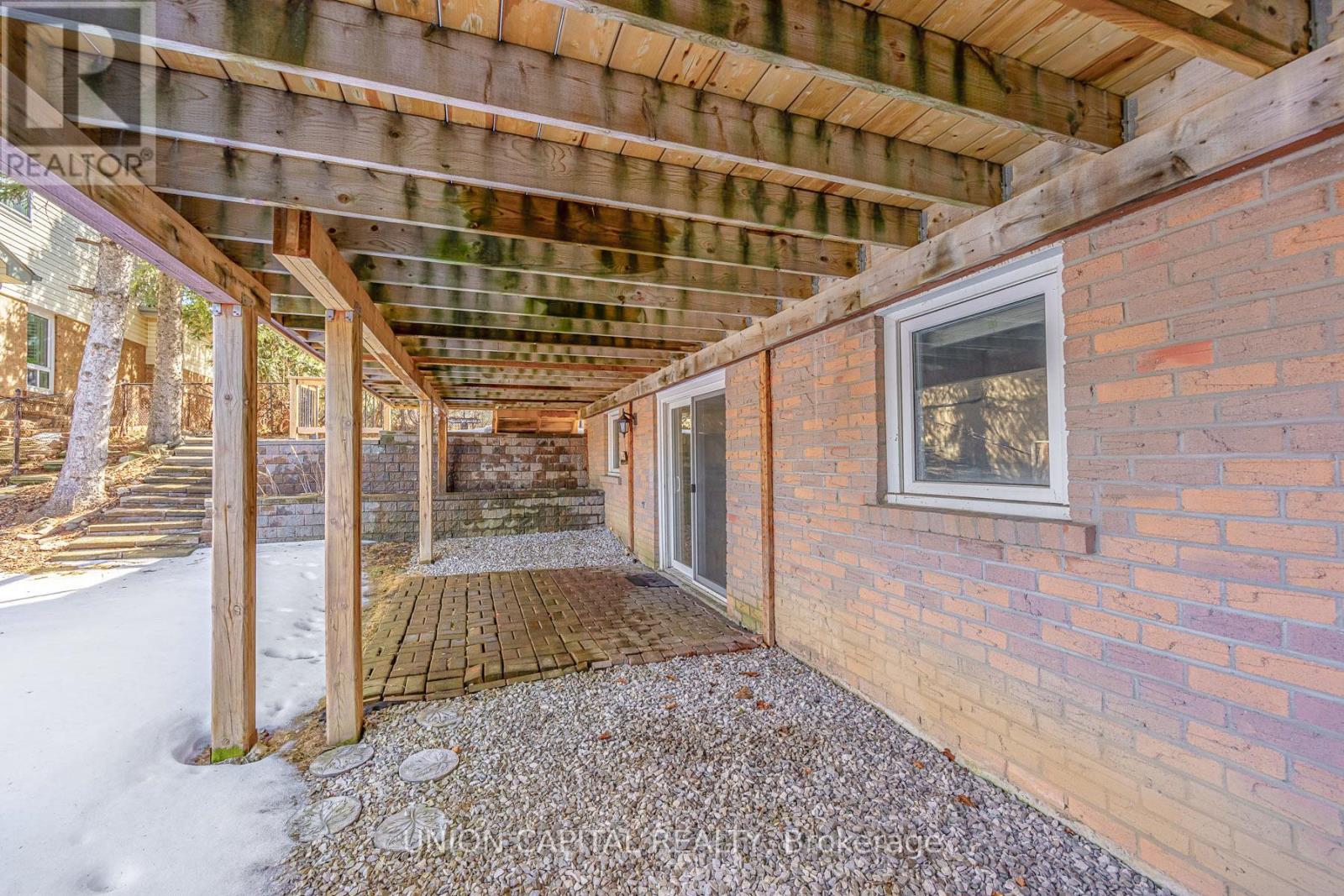 A wooden covered walkway leads to a house.