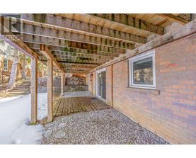 A wooden covered walkway leads to a house.