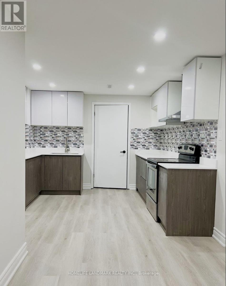 A kitchen with white cabinets and a tiled backsplash.