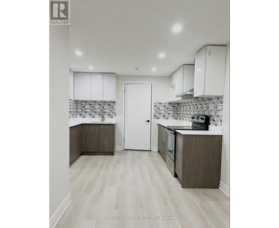 A kitchen with white cabinets and a tiled backsplash.