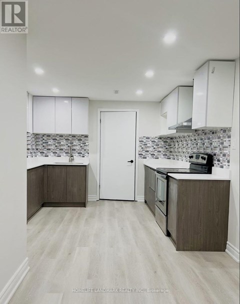 A kitchen with white cabinets and a tiled backsplash.