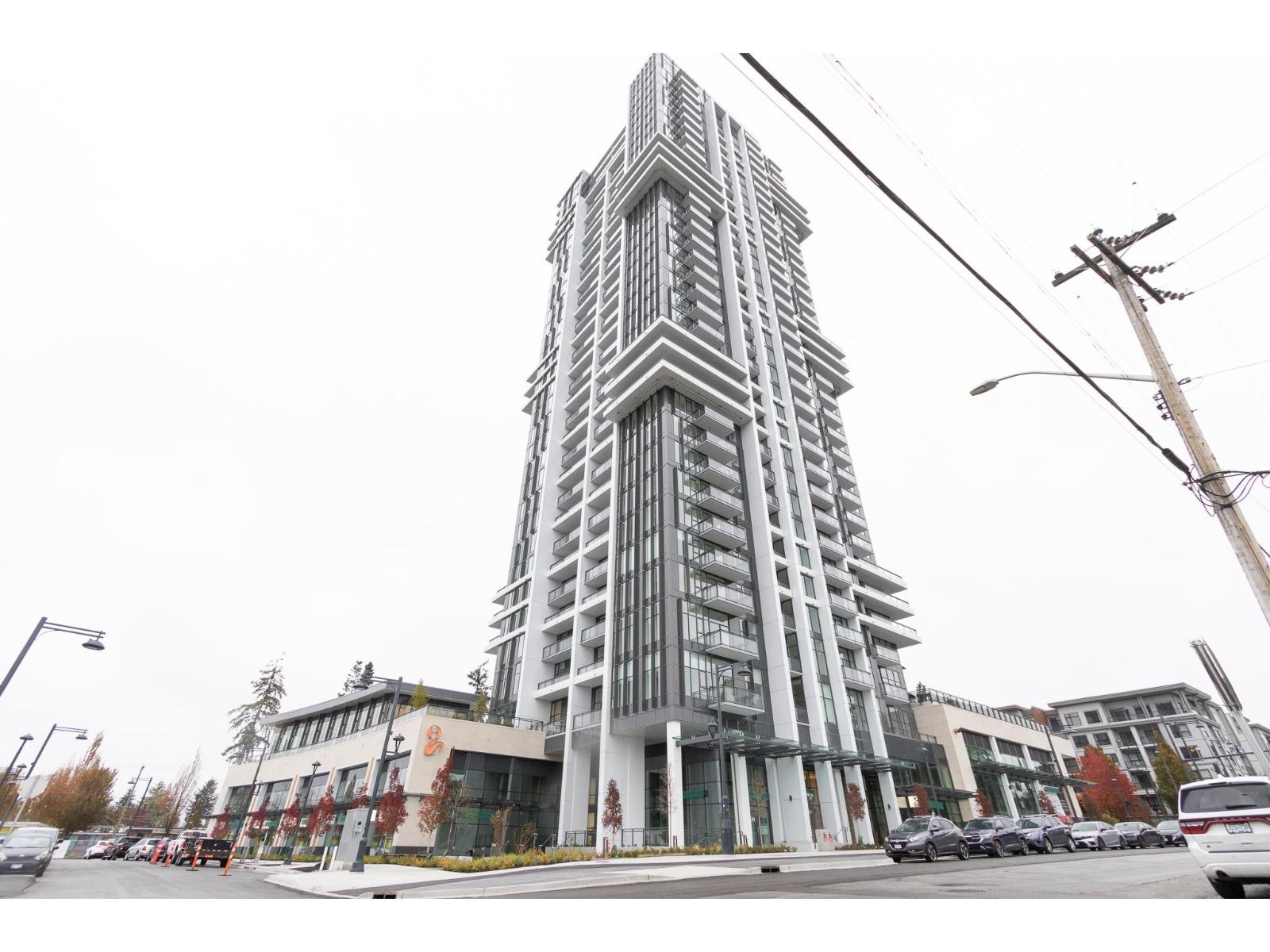 A tall building with a lot of windows is in the middle of a street.
