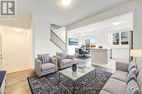 A living room with a glass coffee table and a blue rug.