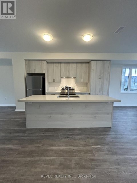 A kitchen with a sink and a refrigerator.