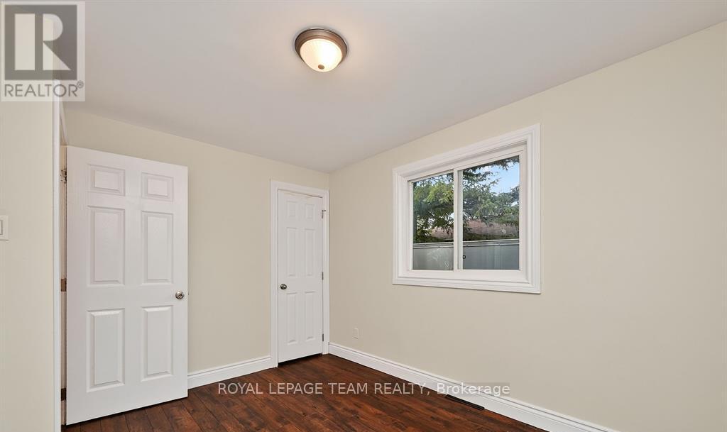A white door and a window with a view of trees and a lake.