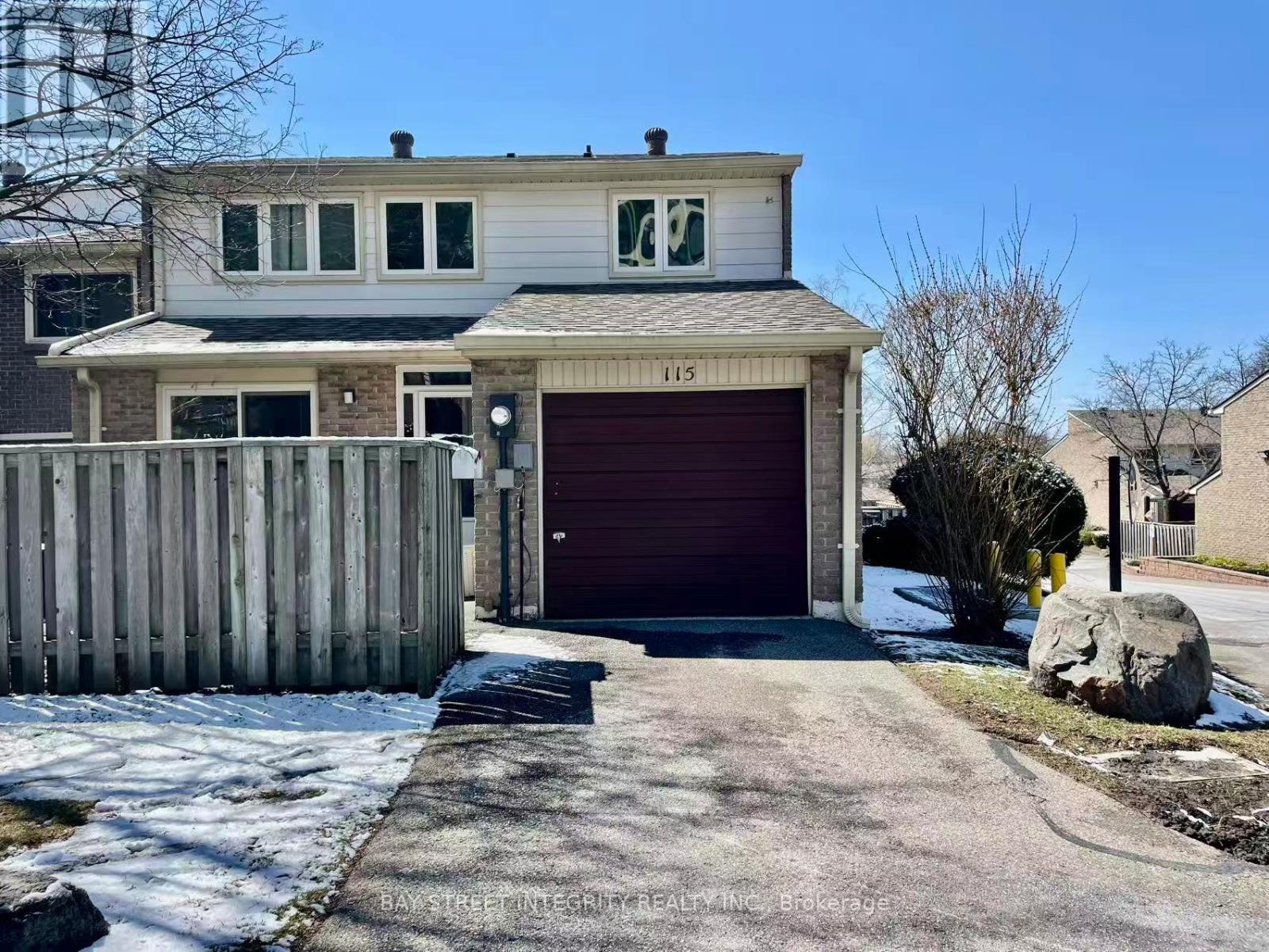 A two-story house with a garage and a driveway in front.