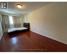 A bedroom with a bed, a television, and a window with curtains.
