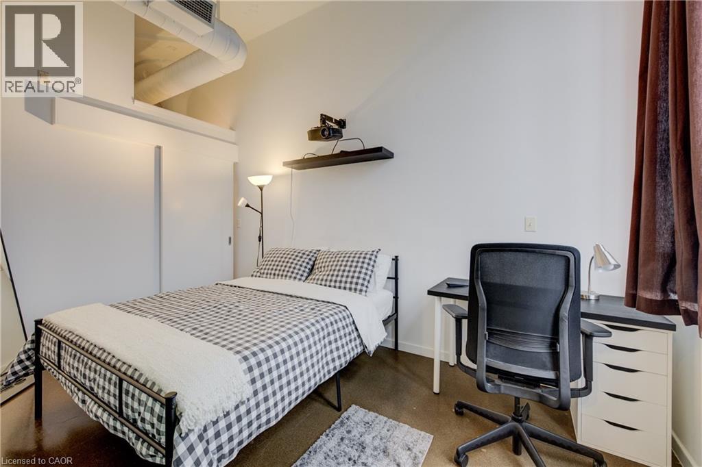 A bedroom with a bed, desk, and chair.