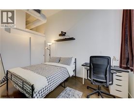 A bedroom with a bed, desk, and chair.