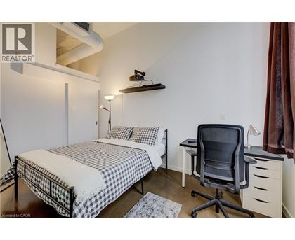 A bedroom with a bed, desk, and chair.