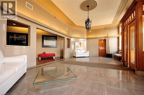 A spacious living room with a glass coffee table and a red sofa.