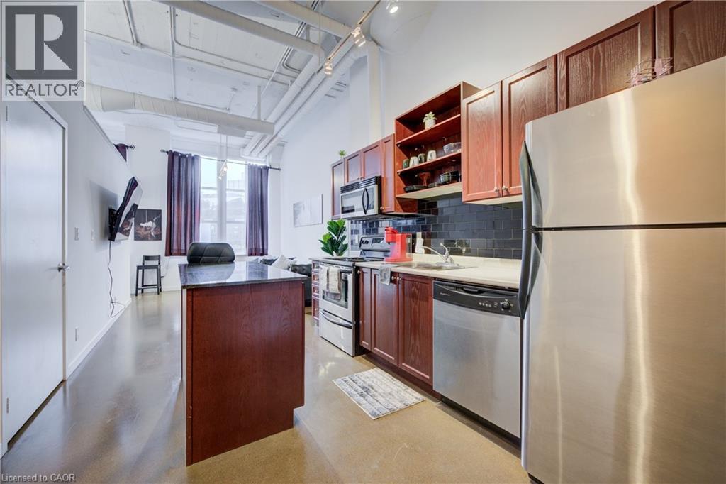 A kitchen with a refrigerator on the right side.
