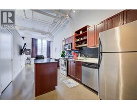 A kitchen with a refrigerator on the right side.