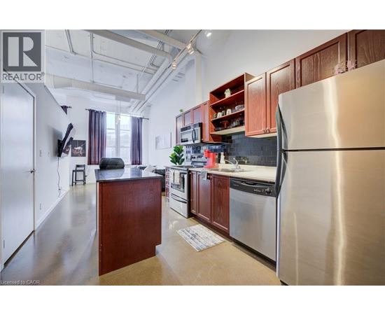 A kitchen with a refrigerator on the right side.