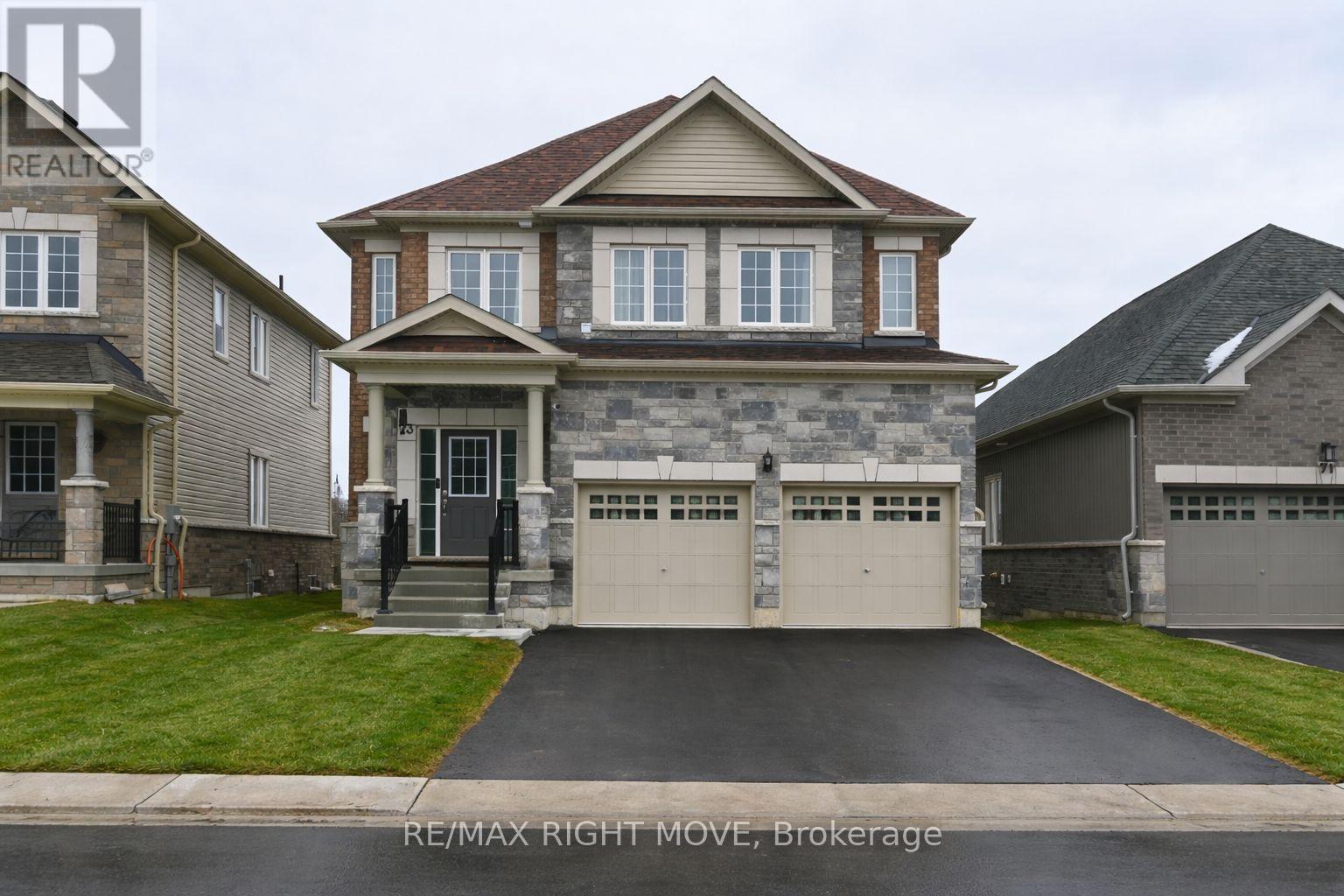 A large house with a stone facade and a garage is for sale.