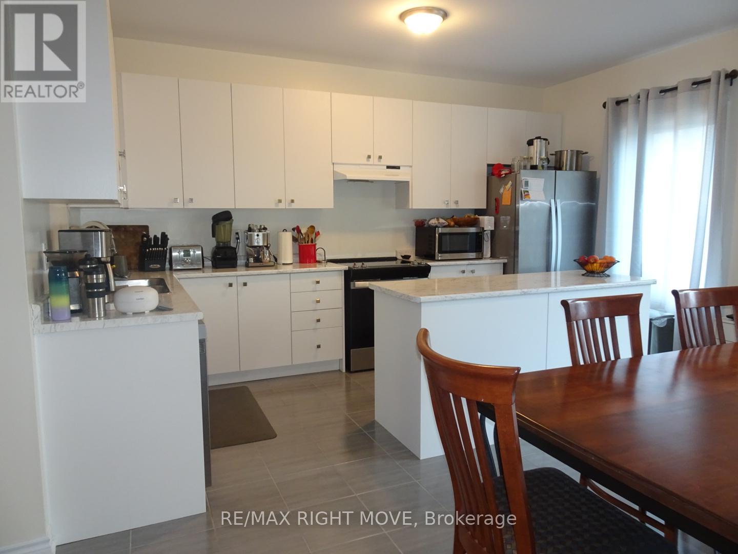 A kitchen with white cabinets and a wooden table.