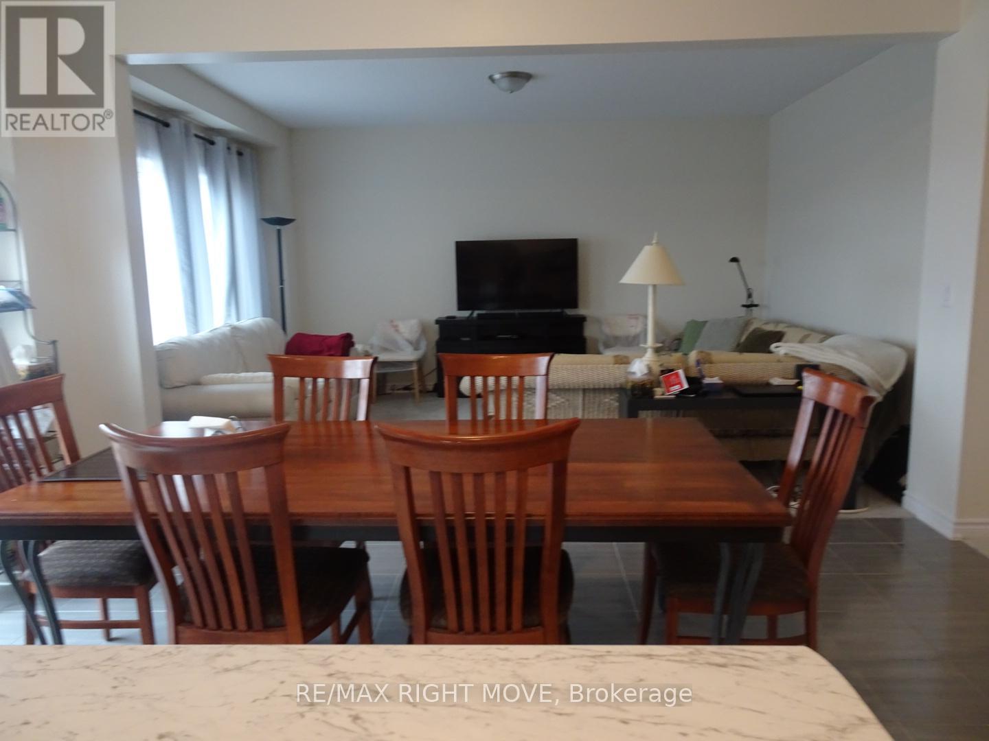 A dining room with a wooden table and chairs.