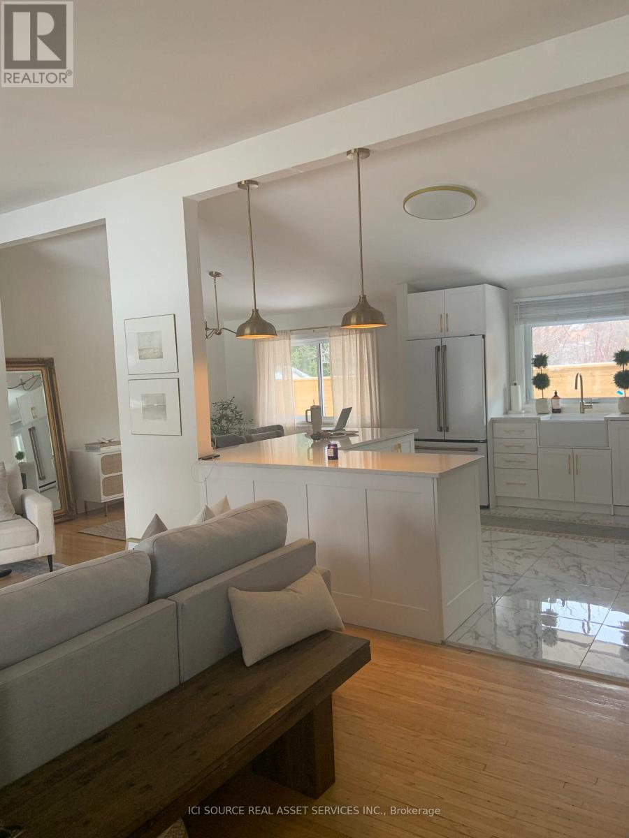 A modern kitchen with a grey sofa and wooden table.