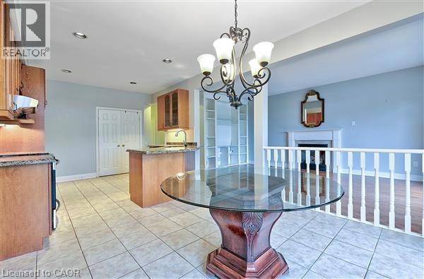 A dining room with a glass table and a chandelier.