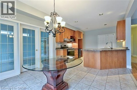 A modern kitchen with a glass table and a chandelier.